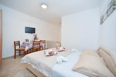 a bedroom with a bed and a table with chairs at Apartmani Bonik in Budva