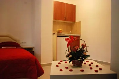 a kitchen with a table with a bouquet of flowers at Apartmani Bonik in Budva