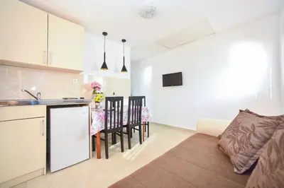 a kitchen and living room with a couch and a table at Apartmani Bonik in Budva