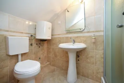 a bathroom with a toilet and a sink and a mirror at Apartmani Bonik in Budva