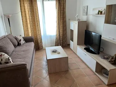 a living room with a couch and a tv at Comfort Apartment El Mar in Sveti Stefan