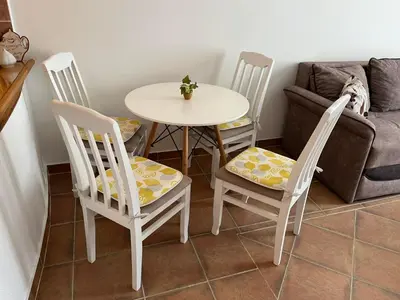 a table and chairs and a table and a couch at Comfort Apartment El Mar in Sveti Stefan