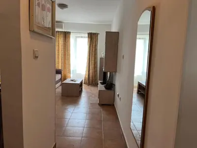 a hallway with a mirror and a living room at Comfort Apartment El Mar in Sveti Stefan