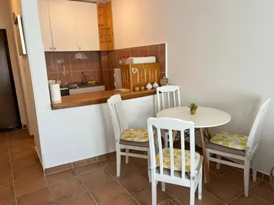 a kitchen with a table and chairs and a counter at Comfort Apartment El Mar in Sveti Stefan