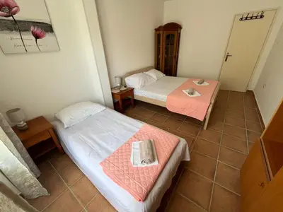 a room with two beds and a table in it at Comfort Apartment El Mar in Sveti Stefan