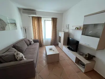 a living room with a couch and a flat screen tv at Comfort Apartment El Mar in Sveti Stefan