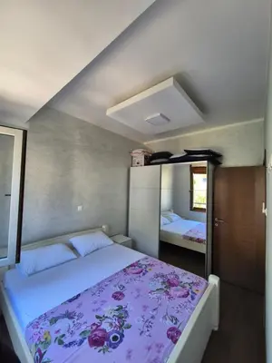 a bedroom with a large bed with a purple blanket at Petrovac in Petrovac na Moru