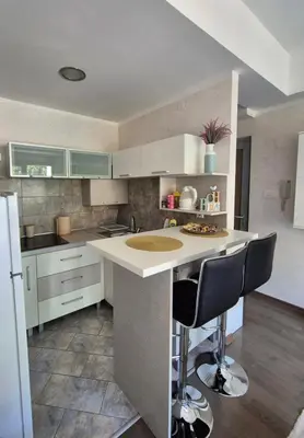 a kitchen with a counter and two bar stools at Petrovac in Petrovac na Moru