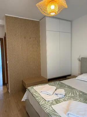 a bedroom with two beds and a cabinet and a chandelier at Villa Firenze in Ulcinj