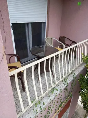 a balcony with chairs and a table and a window at Relax Hostel Bar in Podgorica