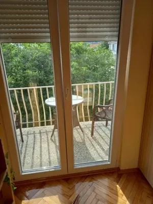 a room with sliding glass doors and a table on a balcony at Relax Hostel Bar in Podgorica