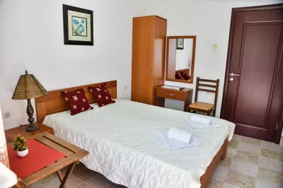 a bedroom with a bed and a table and a mirror at Elsa in Ulcinj