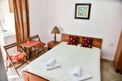 a bedroom with a bed and a table and a chair at Elsa in Ulcinj