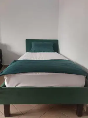 a bed with a green and white comforter at Sea View apartment in Budva in Budva
