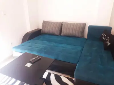 a living room with a blue couch and a table at Sea View apartment in Budva in Budva