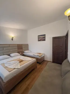 a room with two beds and a chair in it at Apartments George in Ulcinj