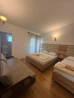 a bedroom with two beds and a couch at Apartments George in Ulcinj