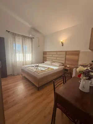 a bedroom with a bed and a table in it at Apartments George in Ulcinj