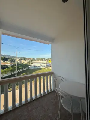 a room with a balcony with a table and chairs at Apartments George in Ulcinj