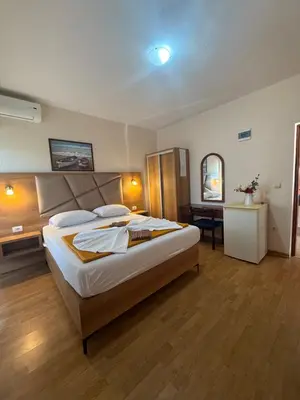a bedroom with a large bed and a desk at Apartments George in Ulcinj