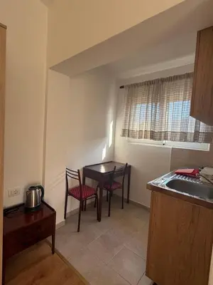 a kitchen with a table and two chairs and a sink at Apartments George in Ulcinj