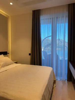a bedroom with a bed and a large window at ZOA Seaview Apartment in Becici