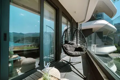 a chair sitting on the balcony of a house at ZOA Seaview Apartment in Becici