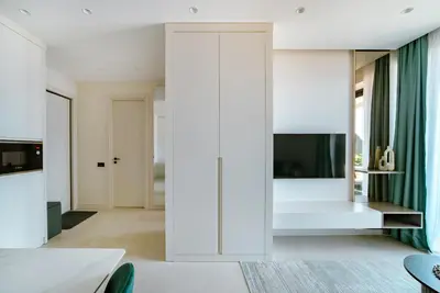 a bedroom with white walls and a bed with a window at ZOA Seaview Apartment in Becici