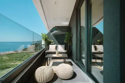 a balcony with two chairs and a table with a view at ZOA Seaview Apartment in Becici
