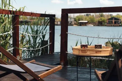 a wooden deck with a chair and a table and water at River Breeze in Ulcinj