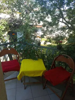 two chairs with a yellow blanket sitting on a balcony at Apartman aleksej in Kućišta