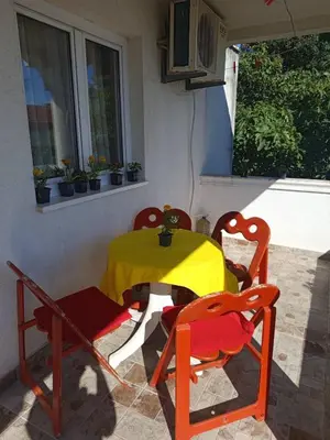 a table with two chairs and a yellow table cloth at Apartman aleksej in Kućišta