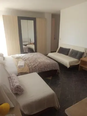 a hotel room with two beds and a couch at Apartman aleksej in Kućišta