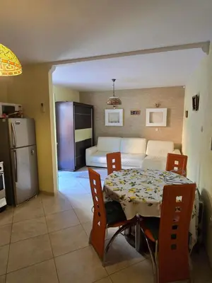 a kitchen and a dining room with a table and a couch at Sunny Lemon Garden in Petrovac na Moru