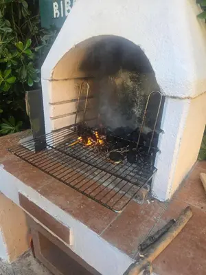 a brick oven with a fire inside of it at Sunny Lemon Garden in Petrovac na Moru