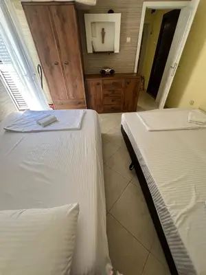 a bedroom with two beds and a dresser at Sunny Lemon Garden in Petrovac na Moru