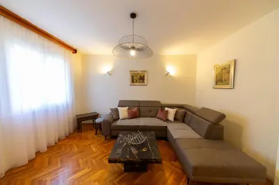 a living room with a couch and a table at KENOVA Apartment in Dobrota