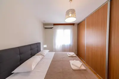 a room with a large bed with a window at KENOVA Apartment in Dobrota