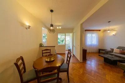 a living room with a table and a couch at KENOVA Apartment in Dobrota