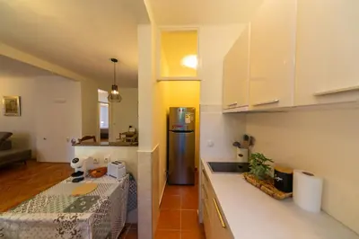 a kitchen with a table and a refrigerator at KENOVA Apartment in Dobrota