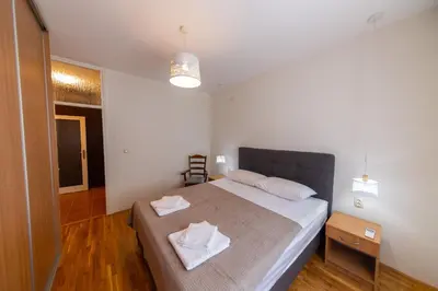 a bedroom with a large bed with two towels on it at KENOVA Apartment in Dobrota