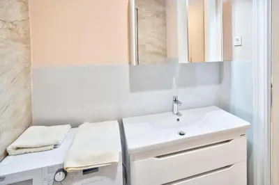a white bathroom with a sink and a mirror at Skyline Premium Residences Becici in Becici
