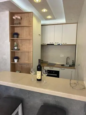 a kitchen with two glasses of wine on a counter at Apartman Vuk in Budva
