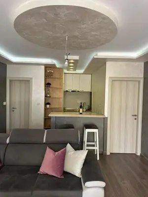 a living room with a couch and a kitchen at Apartman Vuk in Budva