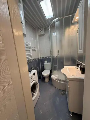 a bathroom with a toilet a sink and a washing machine at Studio apartman Melissa in Budva