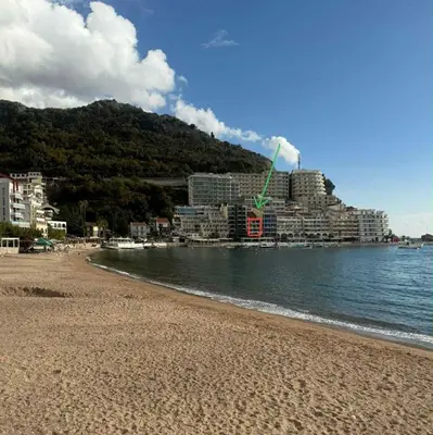 a beach with buildings in the background and the ocean at Studio apartman Melissa in Budva