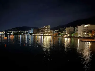 a city at night with lights on the water at Studio apartman Melissa in Budva