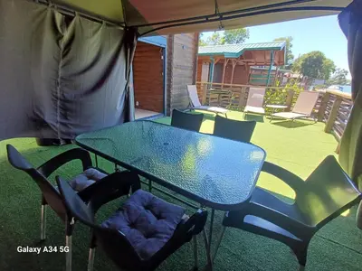a table and chairs sitting under a tent on a patio at Mimas HOUSE ADA BOJANA in Ulcinj