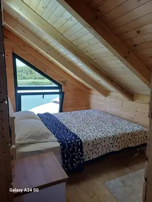 a bed in a room in a wooden cabin at Mimas HOUSE ADA BOJANA in Ulcinj