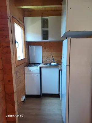 a small kitchen with white appliances and a refrigerator at Mimas HOUSE ADA BOJANA in Ulcinj